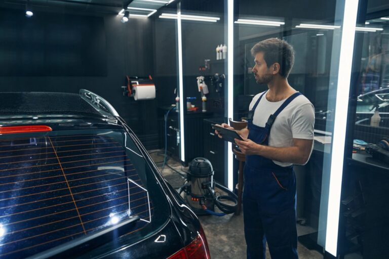 worker-of-car-service-entering-information-about-detailing-to-tablet